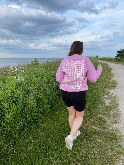 Model showing the back of the gluten free crewneck sweater that reads 