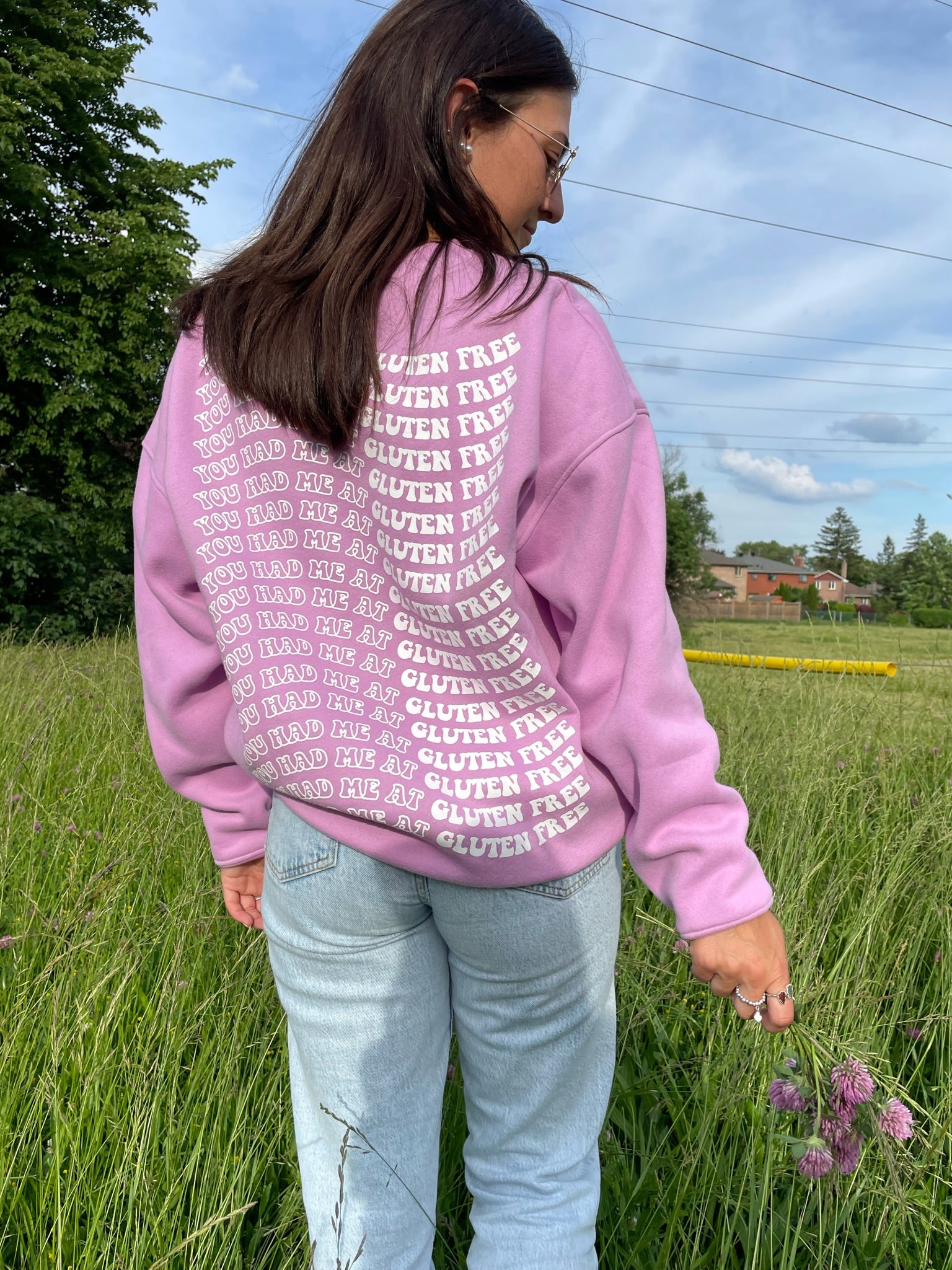 Model showing the back of the crewneck that reads "You Had Me at Gluten Free".