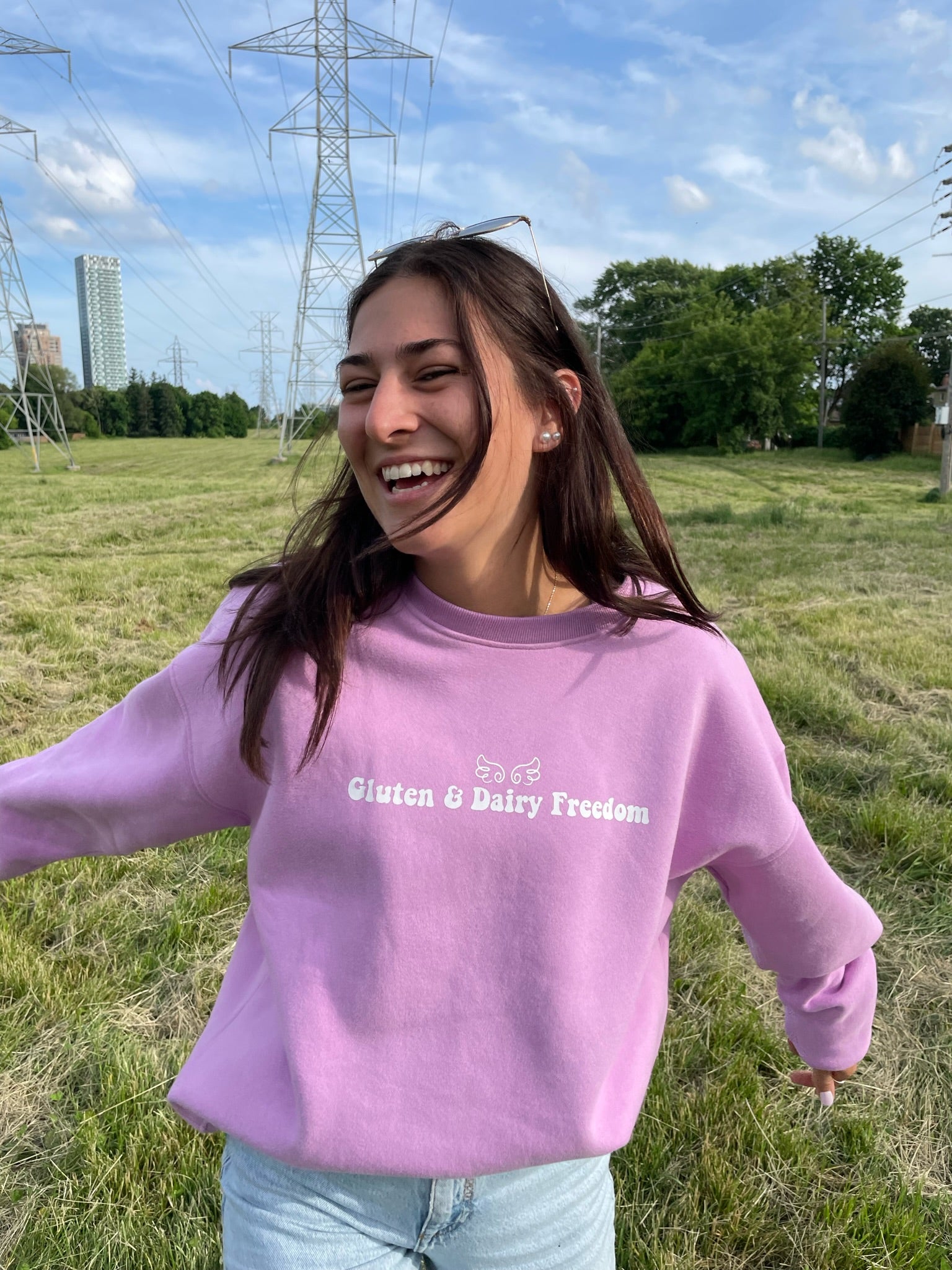 Model showing the front of the pink gluten free crewneck with the name "Gluten & Dairy Freedom" in the centre.